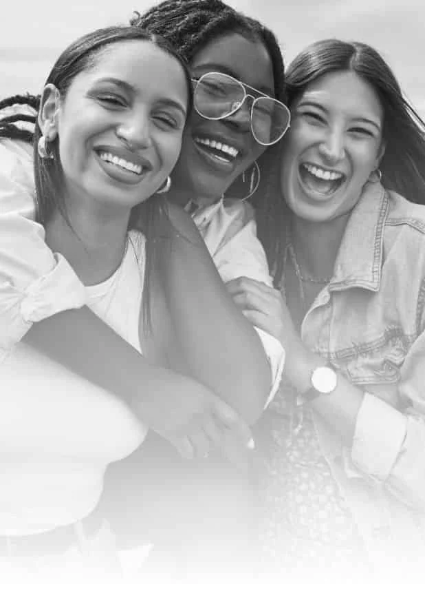 Three friends smiling outdoors black and white
